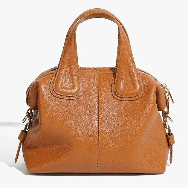 Brown leather handbag with gold hardware and short handles on white background