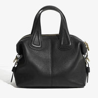 Black leather handbag with top handles and gold zipper on a white background