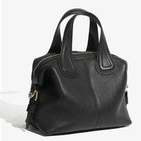 Black leather handbag with top handles and gold zipper on a white background