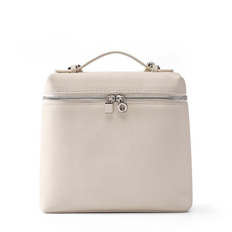 Beige leather handbag with top handle and silver zipper on white background