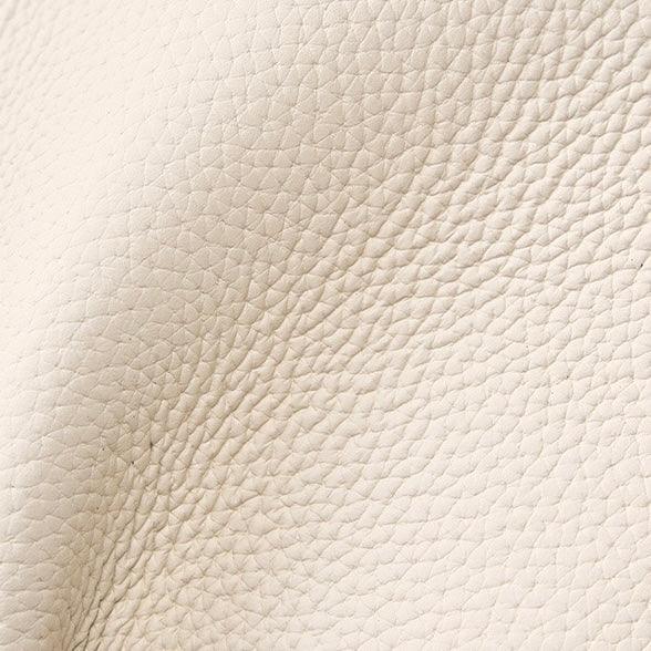 Close-up of beige textured leather material with natural grain pattern