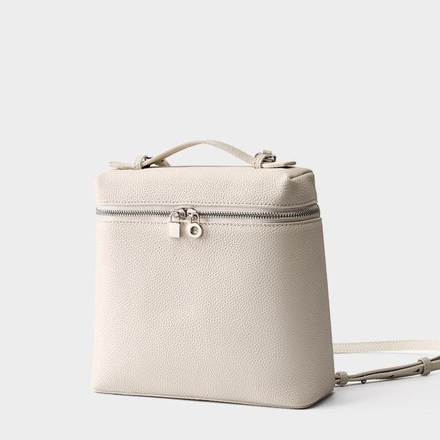 Beige leather square backpack with silver zipper and lock, minimalist design