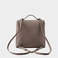 Taupe leather backpack with adjustable straps and top handle on white background