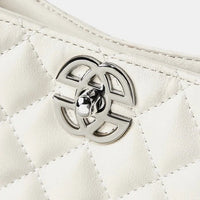 Close-up of quilted white leather handbag with silver metal turn-lock clasp