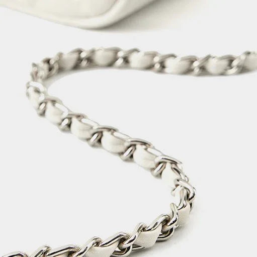 Silver chain strap on white leather handbag, minimalist purse accessory close-up