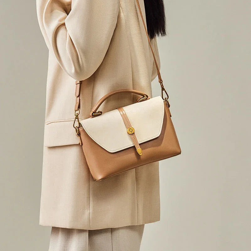 Woman wearing beige suit with a stylish two-tone leather crossbody handbag