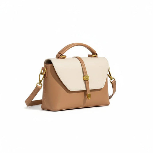 Beige and tan leather handbag with top handle, gold hardware, and shoulder strap on white background