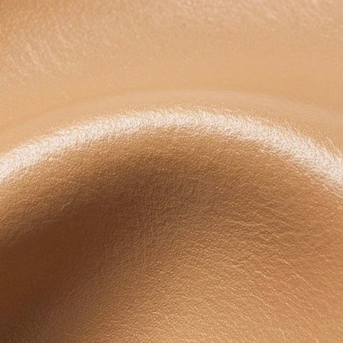 Close-up of smooth beige leather texture with curved contour for upholstery or accessories