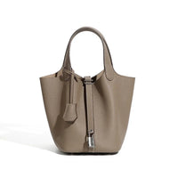 Taupe leather bucket bag with top handles and silver padlock, luxury handbag on white background