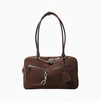 Brown suede leather handbag with silver zippers and double shoulder straps on light background
