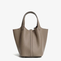 Taupe leather tote bag with pebbled texture and double handles on white background