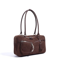 Brown suede shoulder handbag with double straps and front zip pockets on white background