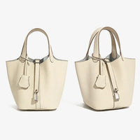 Two beige leather tote handbags with top handles and silver hardware on a white background