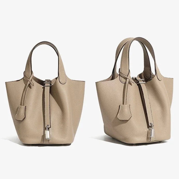 Taupe leather bucket bags with top handles and silver hardware on white background