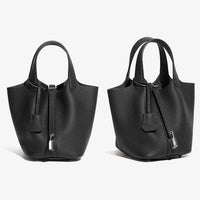 Two black textured leather handbags with top handles and silver clasps on white background