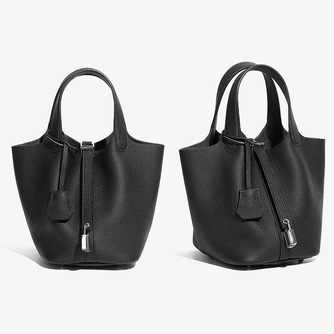 Two black textured leather handbags with top handles and silver clasps on white background