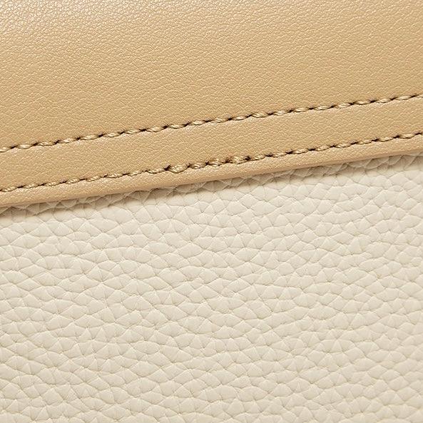 Close-up of beige and cream textured leather with visible stitching detail