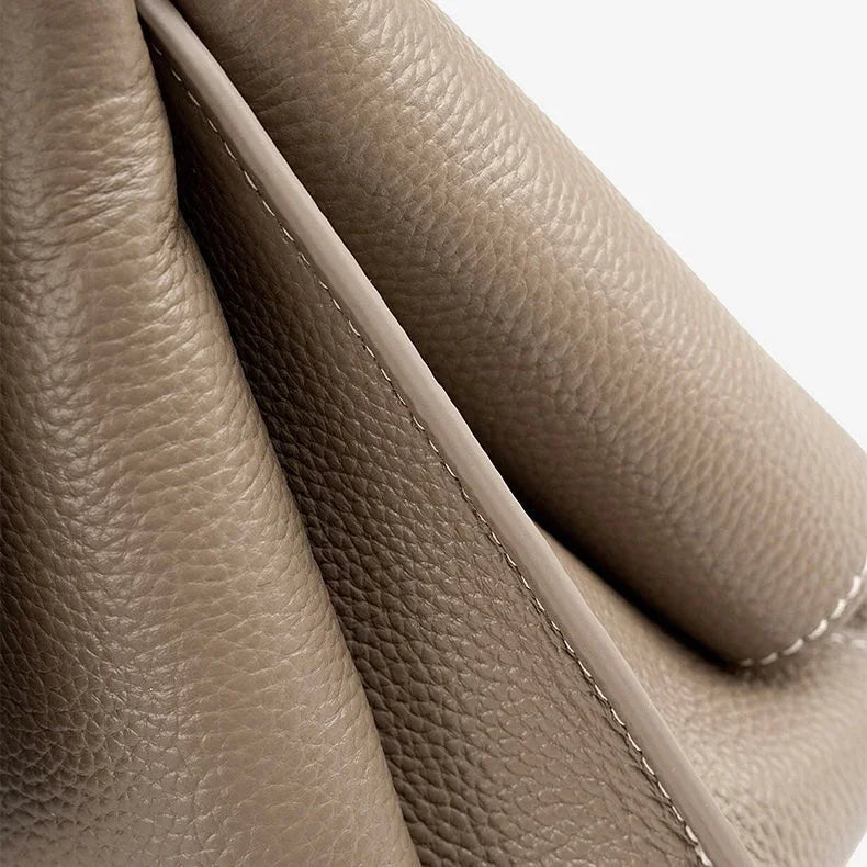 Close-up of taupe pebbled leather handbag with visible stitching detail