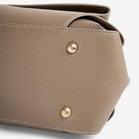 Taupe pebbled leather handbag bottom with gold feet and white stitching detail