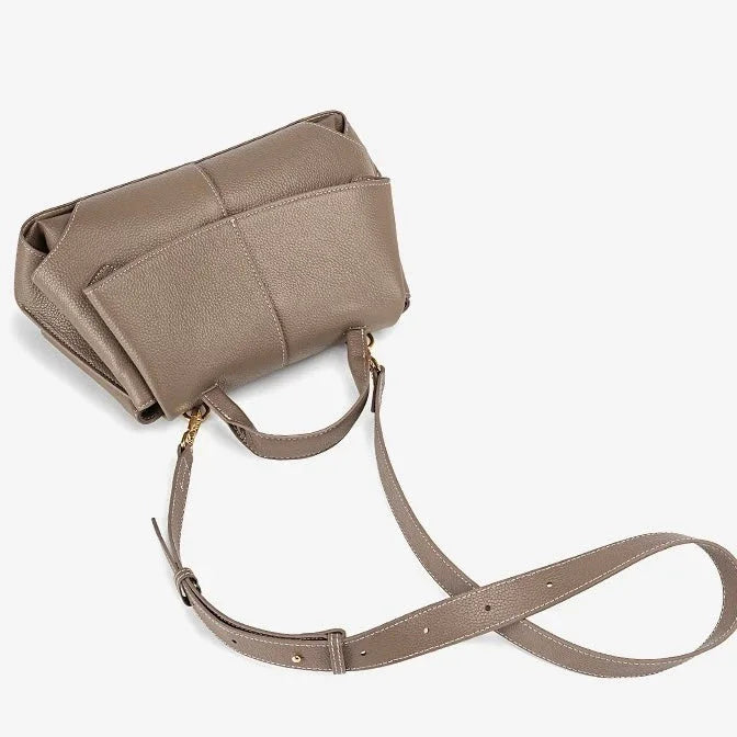 Taupe leather crossbody bag with gold hardware and adjustable strap on white background