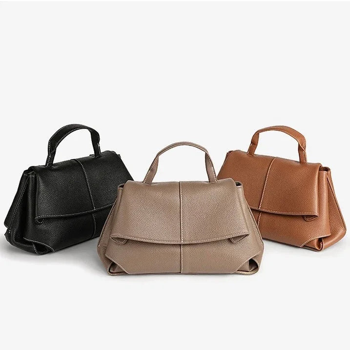 Three structured leather handbags in black, taupe, and brown on white background