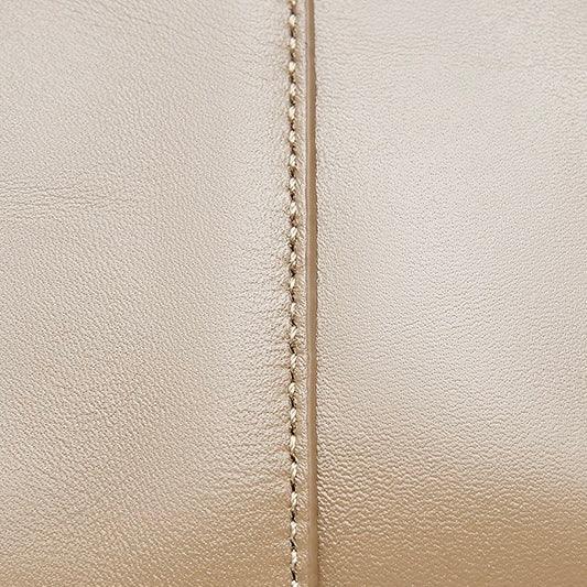 Close-up beige leather texture with visible stitching seam detail