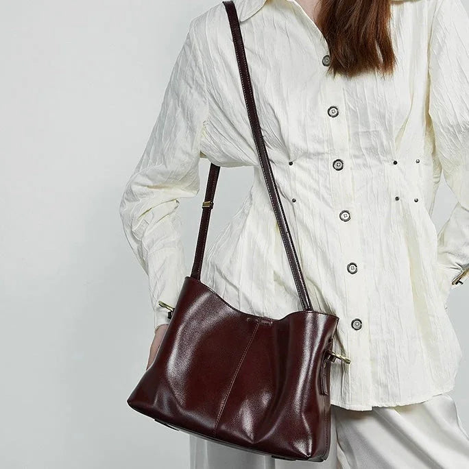 Woman wearing white blouse with brown leather shoulder bag