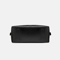 Black leather bag bottom view on white background, classic rectangular handbag base