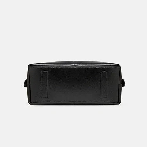 Black leather bag bottom view on white background, classic rectangular handbag base