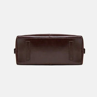 Bottom view of a dark brown leather bag on a white background