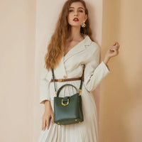 Woman in white dress with brown belt and green leather handbag, fashion photoshoot