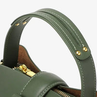 Green leather handbag with gold hardware and adjustable top handle