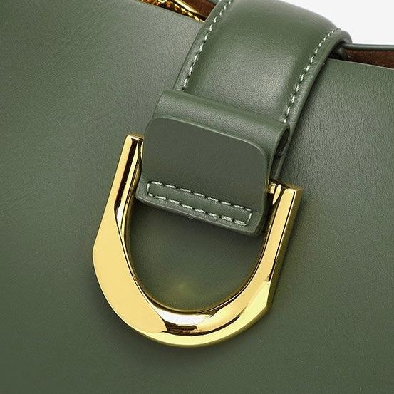 Sage green leather handbag with gold metal buckle close-up