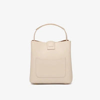 Beige leather handbag with top handle and front pocket against white background
