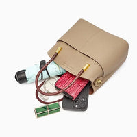 Beige leather handbag with wallet, phone, umbrella, and accessories spilling out