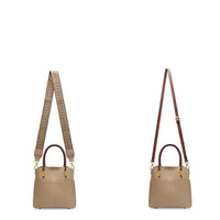 Taupe leather handbags with two different detachable shoulder straps on white background