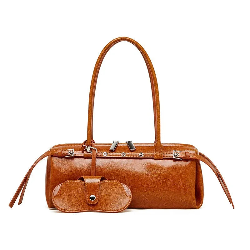 Brown leather handbag with double handles and matching pouch on white background