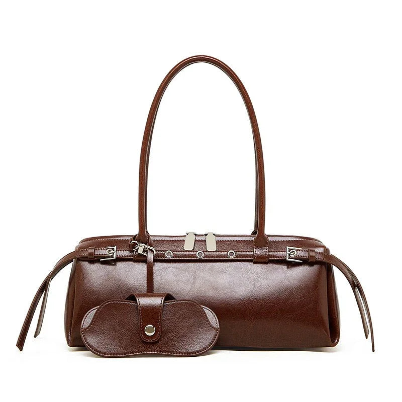 Brown leather handbag with long handles and matching glasses case on white background