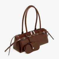 Brown leather handbag with long handles and matching brown pouch on white background