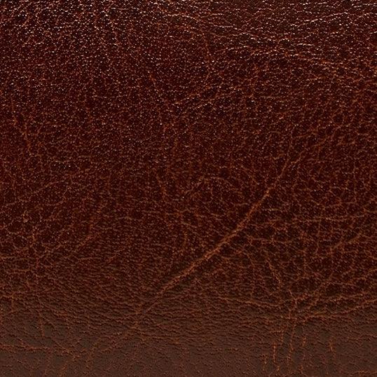 Close-up of brown genuine leather texture with natural grain and creases