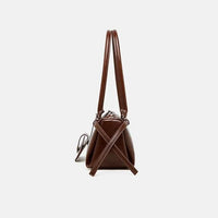 Side view of brown leather handbag with double handles and crossbody strap on white background