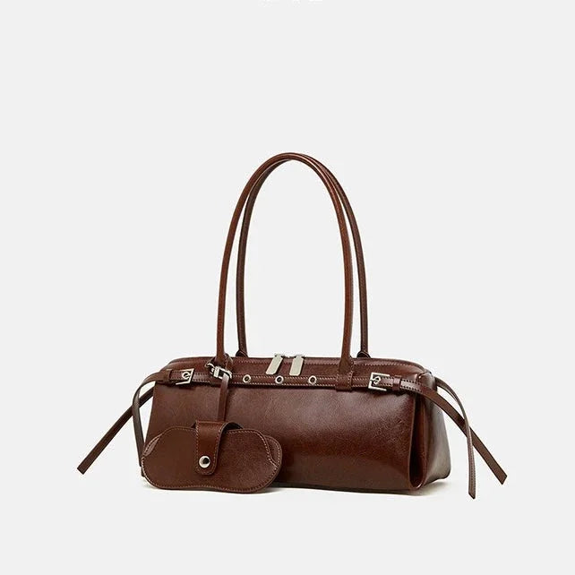 Brown leather handbag with long handles and matching pouch on white background