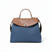 Blue handbag with brown leather flap and handle on white background