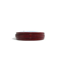 Round brown leather hat box with blue lid on white background