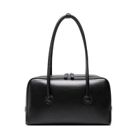 Black leather handbag with double handles and zip closure on white background