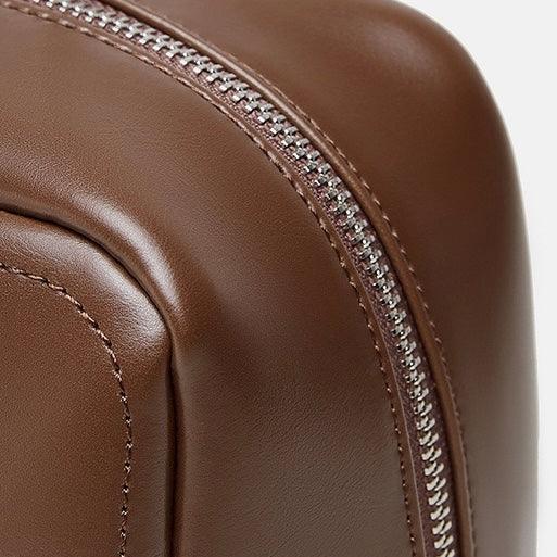 Close-up of brown leather bag with silver zipper detail