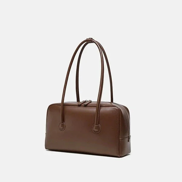 Brown leather handbag with double handles on white background
