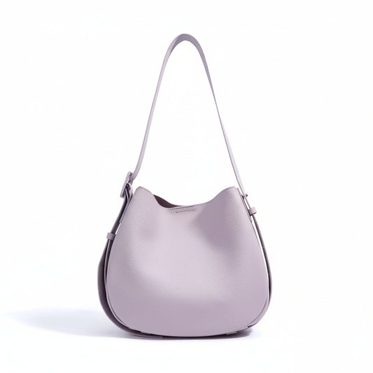 Light purple leather shoulder bag with adjustable strap on white background