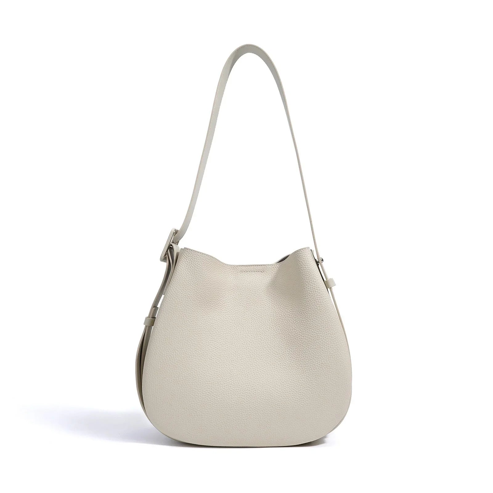 Beige leather shoulder bag with adjustable strap on white background