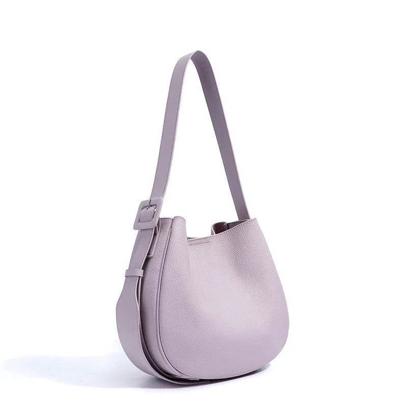 Lilac leather shoulder bag with adjustable strap and minimalist design on white background